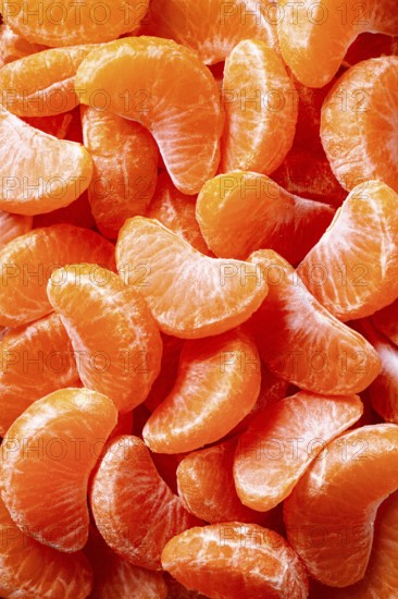 A vivid close-up view of fresh, juicy tangerine slices showcasing their natural, bright orange hue. Perfectly peeled segments depict freshness and citrus vibrancy