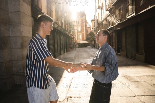 A joyful gay couple holding hands under warm sunlight on a sunny street in Madrid, capturing an intimate moment. Symbolizes love, pride, and togetherness in an urban setting
