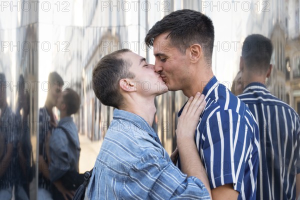 A joyful gay couple shares a tender kiss on the lively streets of Madrid. Their love and connection shine amidst the urban backdrop, celebrating LGBTQIA+ pride