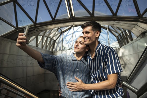 A joyful gay couple takes a selfie on the streets of Madrid. Their happy expressions capture a moment of genuine connection in a vibrant urban setting