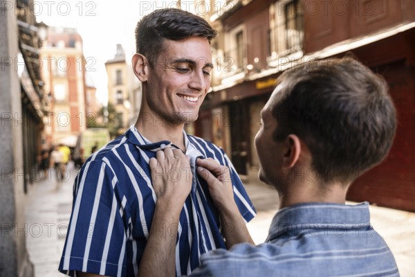A gay couple shares a tender moment on the streets of Madrid. Capturing love and connection in a vibrant urban setting, this image celebrates LGBTQIA+ pride and unity