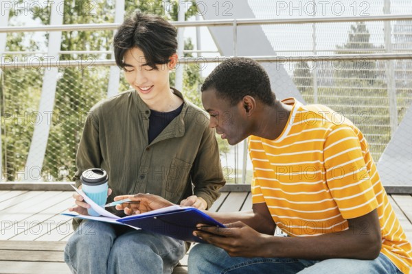Two students friends studying together outdoors, discussing notes and sharing ideas. They are seated on a wooden steps, enjoying the sunshine and academic collaboration