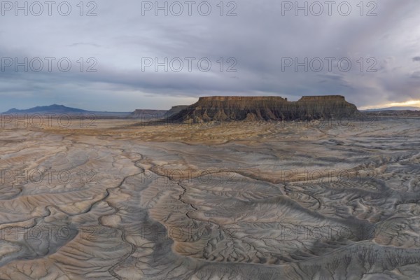 Explore the vast, rugged desert landscape featuring unique geological formations under a dramatic sky in Hanskville, Utah. The earthy textures depict nature raw beauty and timelessness of USA