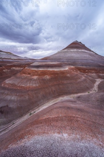 Explore the stunning layers and vibrant colors of the Hanksville Bentonite Hills in Utah. These sedimentary formations create a mesmerizing natural landscape under a dynamic sky