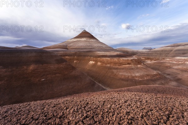 Scenic view of Hanksville Bentonite hills in Utah, USA. The striking patterns and hues create a mesmerizing natural landscape against a backdrop of a vast, cloudy sky