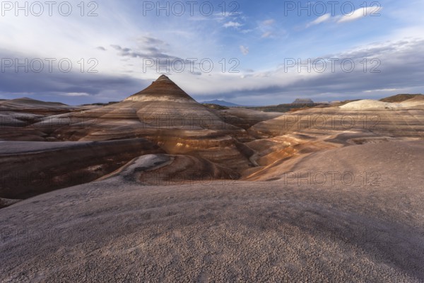 A stunning view of the Hanksville bentonite formations in Utah, USA. The landscape features colorful, layered earth formations beneath a vast, dramatic sky