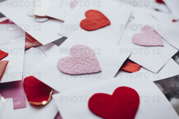 A variety of red and pink felt hearts adorn envelopes, evoking a romantic Valentine's Day atmosphere. Perfect for expressing love and affection through heartfelt messages