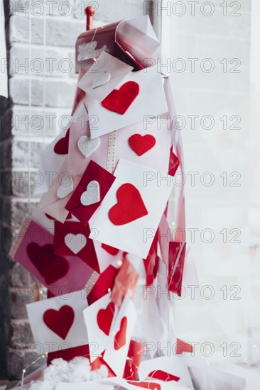 Overflowing mailbox with Valentine's Day envelopes adorned with red and white heart decorations. Symbolizing love, romance, and heartfelt messages