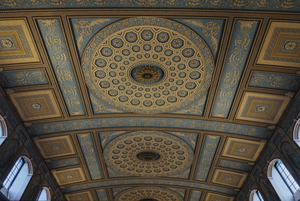 Stunning ornate ceiling in Chapel of St Peter and St Paul in London showcases intricate classical patterns with circular and geometric motifs in blue and gold, reflecting historical architectural elegance