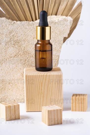 A premium cosmetic dropper bottle displayed on a wooden podium, accompanied by smaller wooden blocks, against a textured stone background