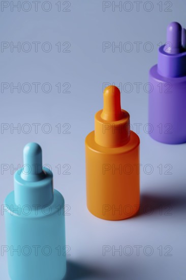 A set of brightly colored serum bottles in orange, purple, and blue against a soft blue background, reflecting clean, minimalistic design