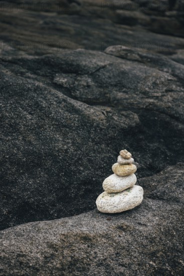 A stack of balanced stones on a rocky surface in a peaceful outdoor environment. Concept of balance, meditation, and tranquility for nature, zen, and mindfulness topics