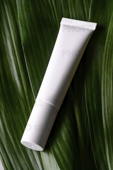 A minimalist presentation of a white cosmetic tube elegantly placed on vibrant green leaves, emphasizing eco-friendly packaging and natural beauty products