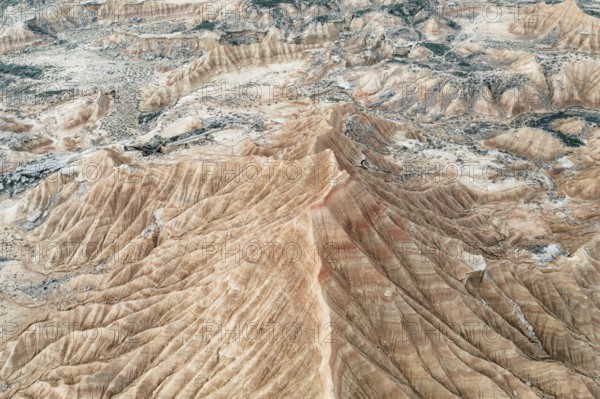 A stunning aerial view captures the intricate patterns of an arid mountain landscape Natural striations and unique formations create a breathtaking texture of earth tones