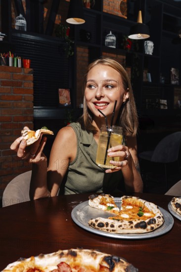 A cheerful person enjoys a slice of Margherita pizza paired with a glass of refreshing citrus lemonade. The scene is set in a cozy restaurant, emphasizing relaxation and culinary delight