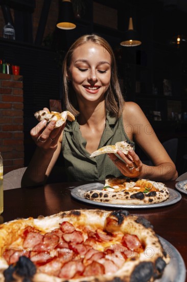 A person enjoys slices of Margherita and Pepperoni pizza paired with a refreshing glass of lemonade, set indoors. The scene showcases a cozy and appetizing dining experience