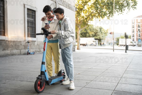 A gay couple shares a moment on a scooter in an urban setting, capturing joy and connection. They embrace while looking at a phone, showcasing modern lifestyle and love