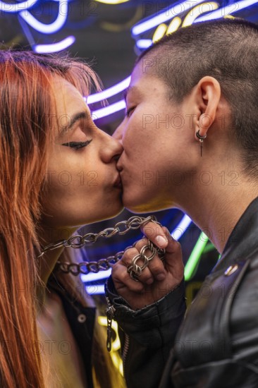 A close-up photo of a lesbian couple kissing passionately, illuminated by vibrant neon lights, capturing the essence of love and connection