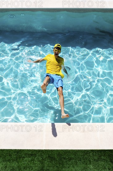 A joyful person in a colorful outfit splashes into a clear blue pool on a sunny day, expressing fun and energy. The vibrant water and lively scene evoke summer enjoyment