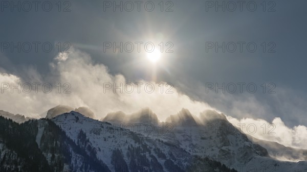 Dramatic winter morning with bright sun shining over the snow covered Les Dents du Midi peaks in the Swiss Alps