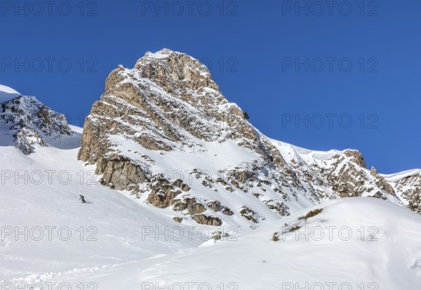 A stunning snow covered mountain peak under a clear blue sky, perfect for winter adventures and the snowboards. The image captures the vastness and beauty of untouched alpine landscapes