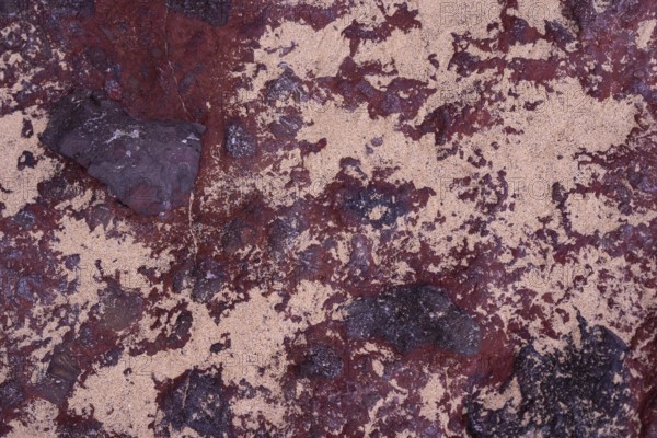 Close-up of the intricate textures of volcanic rocks surrounded by scattered sand at La Pared, Fuerteventura, showcasing natural beauty and geological complexity