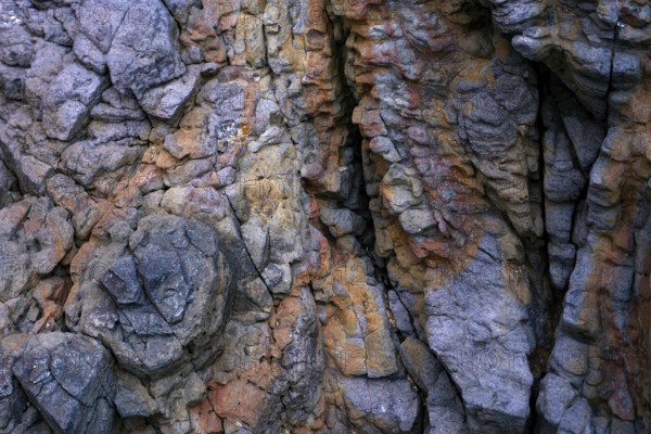 Detailed view of the textured rock formations at Mujeres Beach in Lanzarote, showcasing a variety of colors and intricate geological patterns