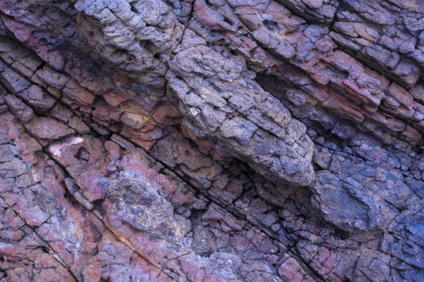 Close-up image displaying the intricate textures and varying colors of volcanic rocks at Mujeres Beach in Lanzarote. Highlighting nature's rugged artistry in detailed formations