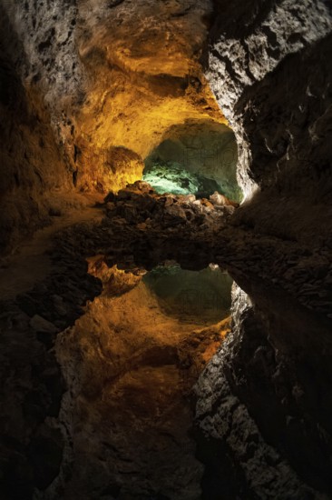 Striking view inside the Cueva de los Verdes in Lanzarote, showcasing beautiful, naturally lit rock formations illuminated with vibrant yellow and green hues