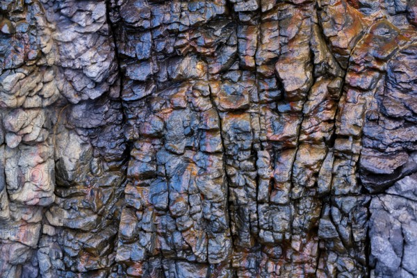 Intricate textures and vibrant mineral hues of the volcanic rock formations in Mujeres Beach, Lanzarote