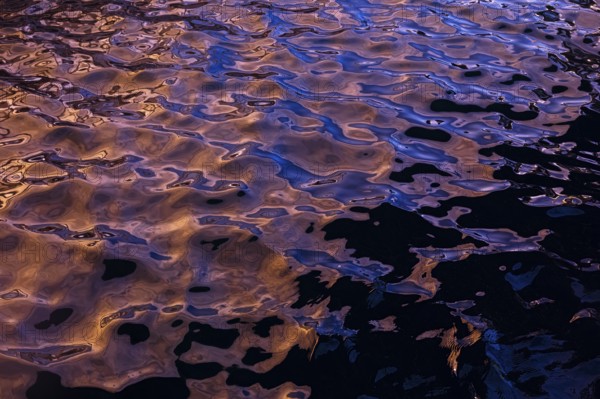 Rippling water creates abstract shapes and textures in this photograph from La Pared, Fuerteventura. The hues reflect a complex blend of blues and golds