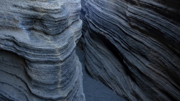 Enigmatic, winding rock formations in Lanzarote, showcasing textured geological layers in shades of gray and black