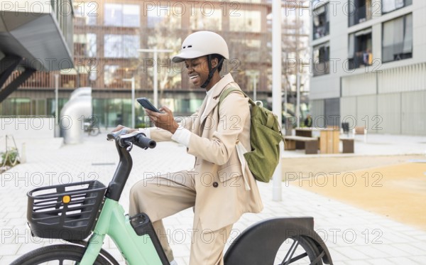 Black woman in a modern urban setting, riding a bicycle and checking her phone Dressed in a light suit, she embodies a contemporary, active lifestyle