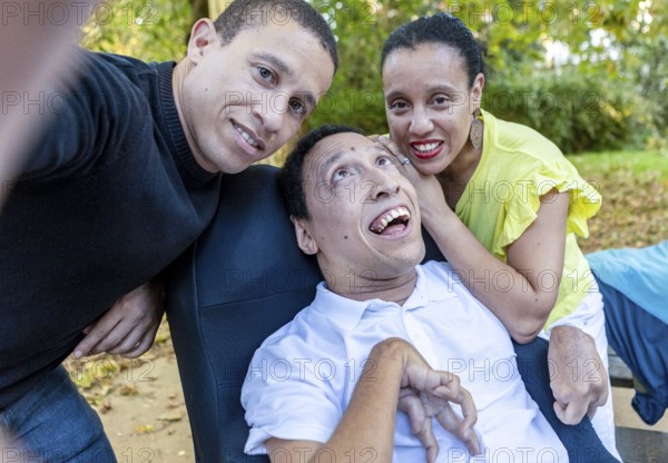 Spanish Cameroonian siblings enjoying a moment outdoors. The family shares a joyful connection, with one sibling having cerebral palsy, illustrating unity and love