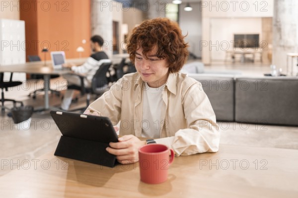 Young professionals working on laptops in a modern, open-plan office The focus is on collaboration, teamwork, and creativity in a comfortable and stylish environment