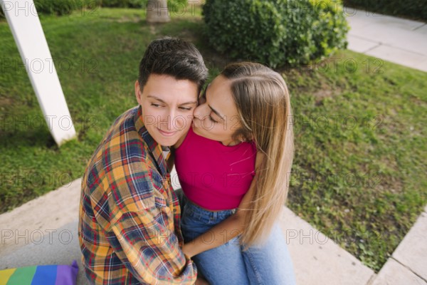 A happy lesbian couple sharing a tender moment outdoors, embracing love and diversity. Their connection reflects pride, equality, and inclusivity in a serene setting