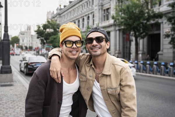 A joyful gay couple is embracing on a bustling city street, showcasing casual style and happiness. Urban environment and modern fashion highlight their vibrant connection