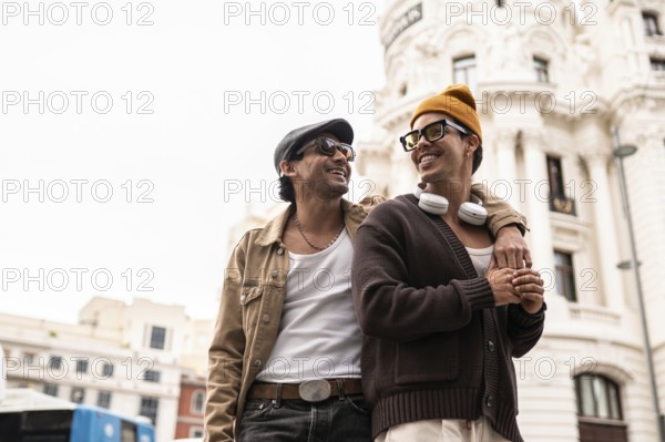 A joyful colombian gay couple enjoying a casual city walk. Both are wearing sunglasses and showcasing happiness and connection against street buildings