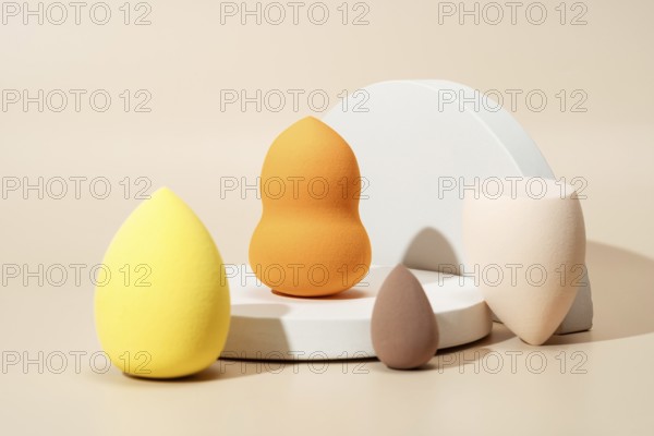 A variety of colorful cosmetic sponges in different shapes and sizes on a light background, designed for makeup application and blending, showcasing versatility and design