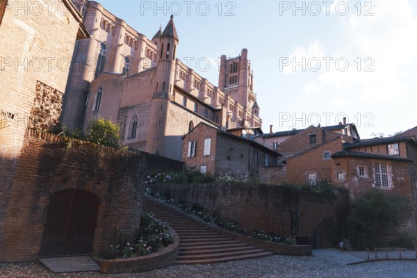 A striking view of a medieval Berbie Palace under a bright, clear sky in Albi, France The image captures the essence of historical architecture and serene urban landscapes