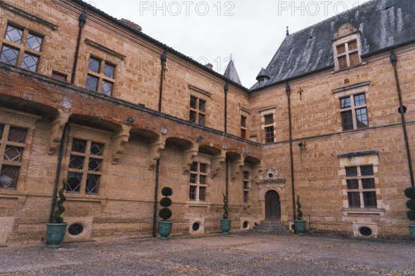 A historic Chateau Caumont castle medieval featuring arched windows and an ornate entrance in France The structure showcases intricate masonry and architectural details, reflecting timeless elegance