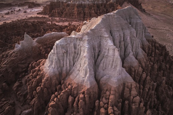 A majestic aerial shot capturing the unique rock formations of Goblin Valley State Park in Utah, USA, bathed in the soft glow of a setting sun