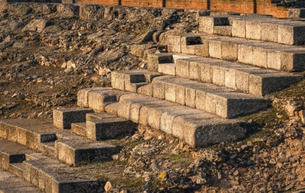 Warm sunlight casts over the stone steps of the ancient Roman theatre in Merida, Badajoz, Spain. This historic site showcases enduring architectural brilliance