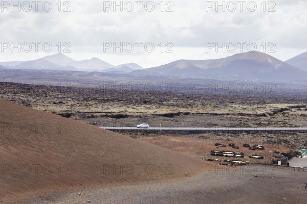Deserted road in a volcanic landscape. The arid terrain and mountains on the horizon highlight the natural beauty of the scene