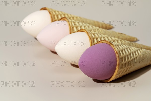 Four colorful cosmetic sponges creatively placed in ice cream cones The sponges, in pastel shades, are artistically arranged, resembling scoops of ice cream