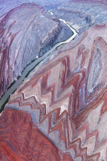 An aerial photograph captures the stunning Rio San Juan as it snakes through the vivid red and grey rock formations of Utah, showcasing the natural beauty and geographical diversity of the area