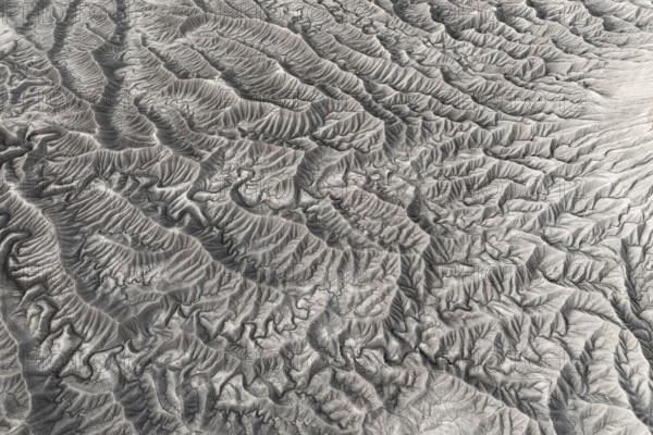 Stark aerial image showcasing the intricate, textured landforms of Caineville Mesa near Hanksville, Utah, highlighting the unique geological patterns