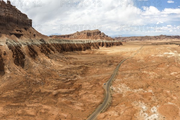 Scenic aerial capture of the unique, eroded rock formations and sprawling terrain at Goblin Valley State Park in Utah, USA, showcasing nature's artwork and winding road cutting through the desert