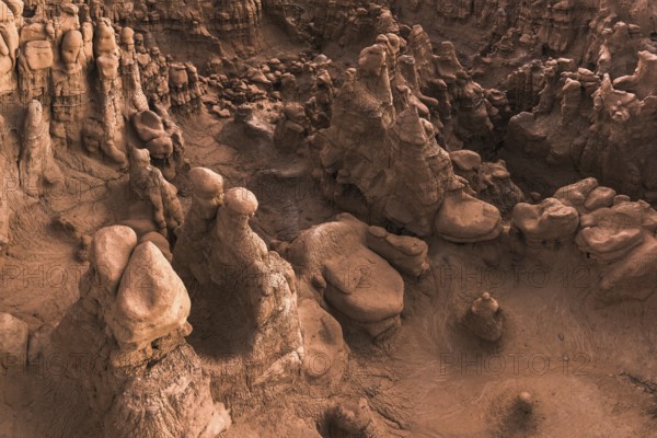 Capture the eerie and fantastical landscape of Goblin Valley State Park in Utah, USA. This image showcases uniquely shaped rock formations resembling goblins, set in a Martian-like terrain under soft lighting