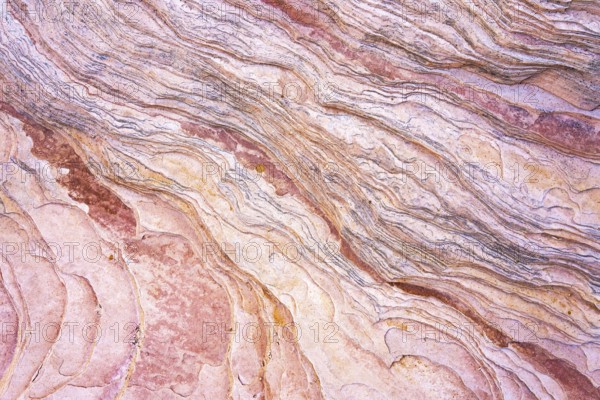 Close-up image showcasing the intricate patterns and warm hues of red rock formations that reveal natural geological lines